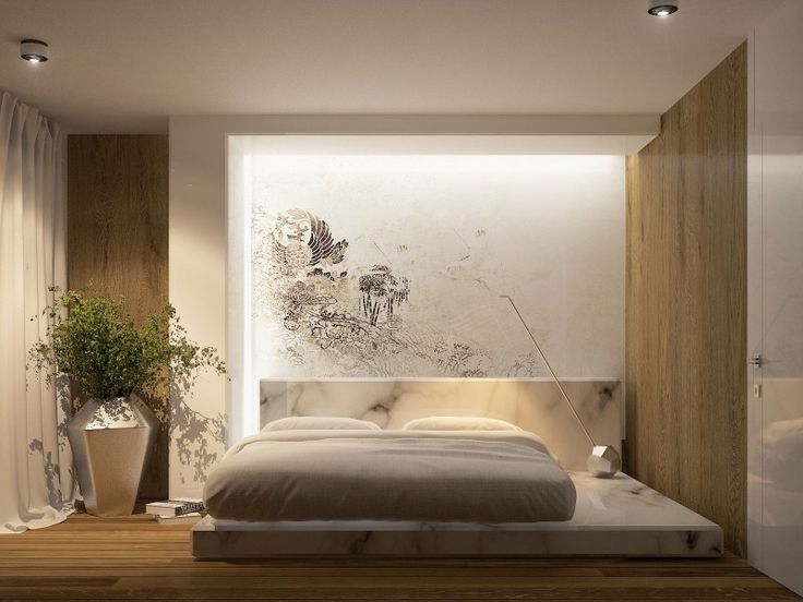 a bedroom with a large bed in the middle and a plant on the wall next to it