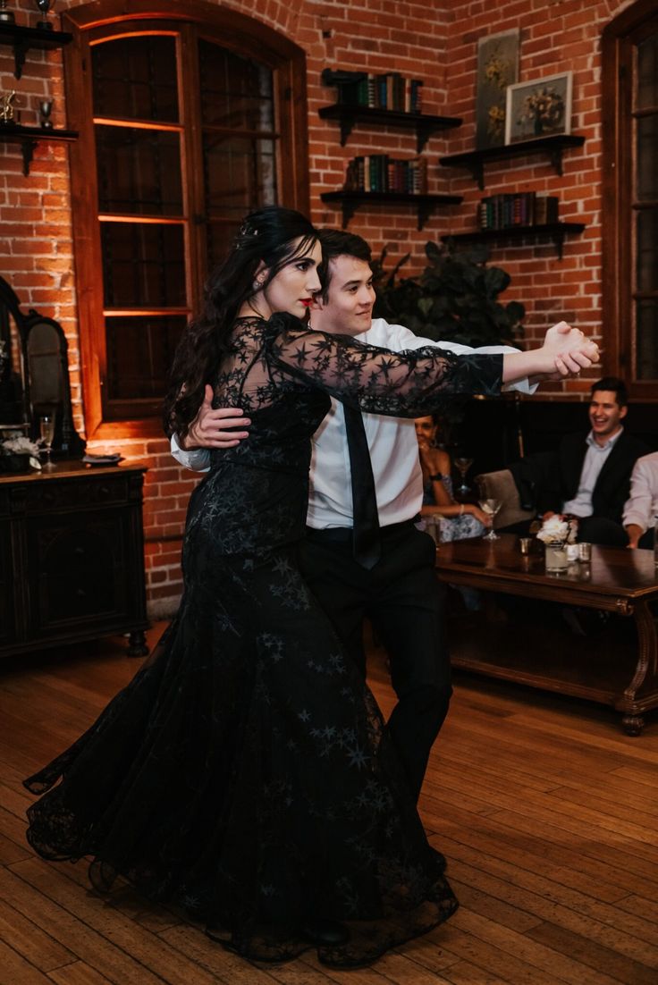 a man and woman dance together in an old - fashioned room with exposed brick walls