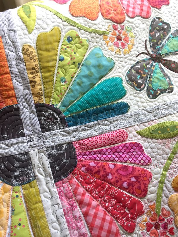 a close up of a colorful quilt with butterflies on it