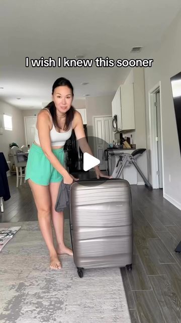 a woman standing next to a piece of luggage