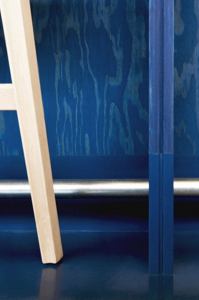 a wooden ladder leaning against a blue wall