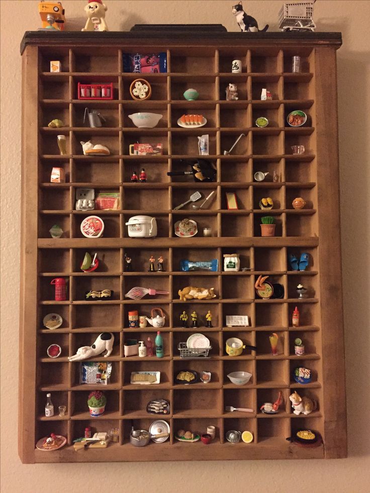 a wooden shelf filled with lots of toy figurines