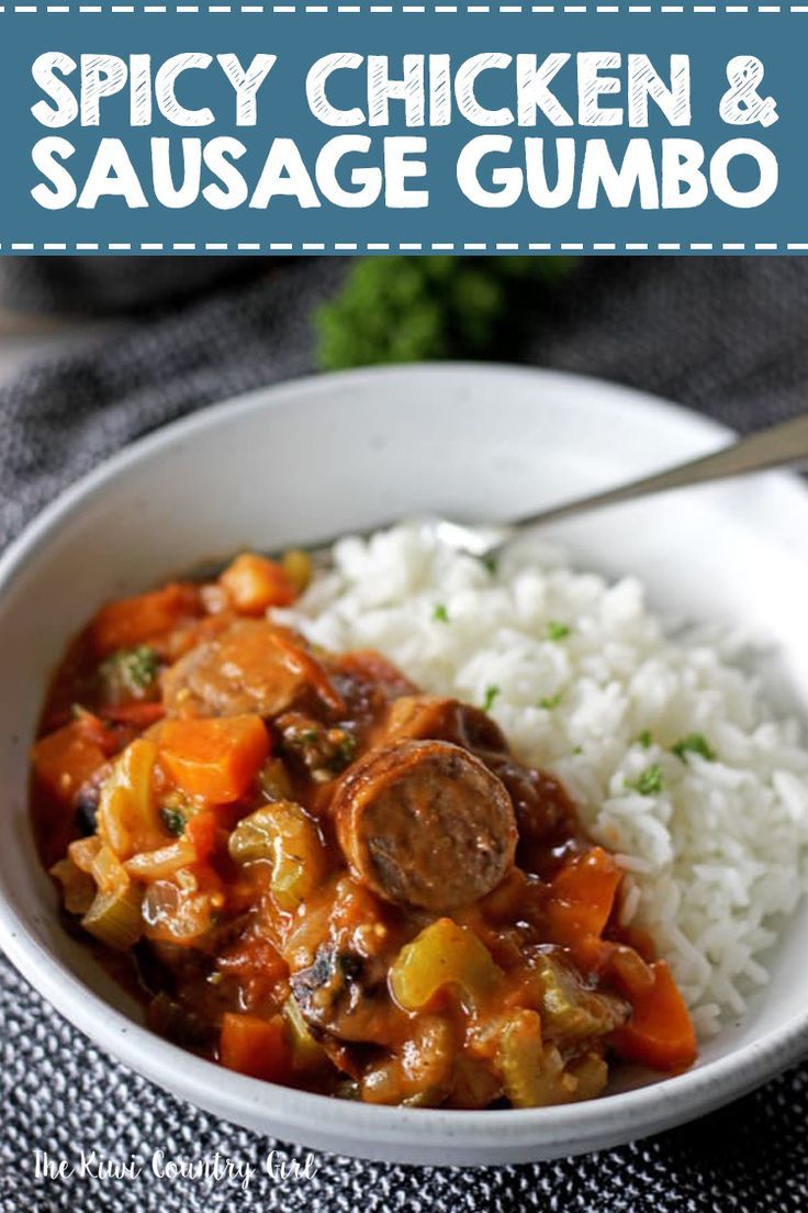 a white bowl filled with stew and rice on top of a table next to a spoon