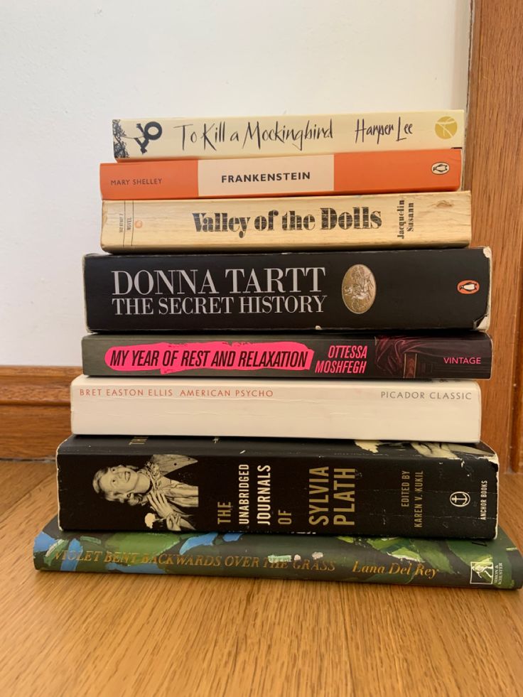 a stack of books sitting on top of a wooden table