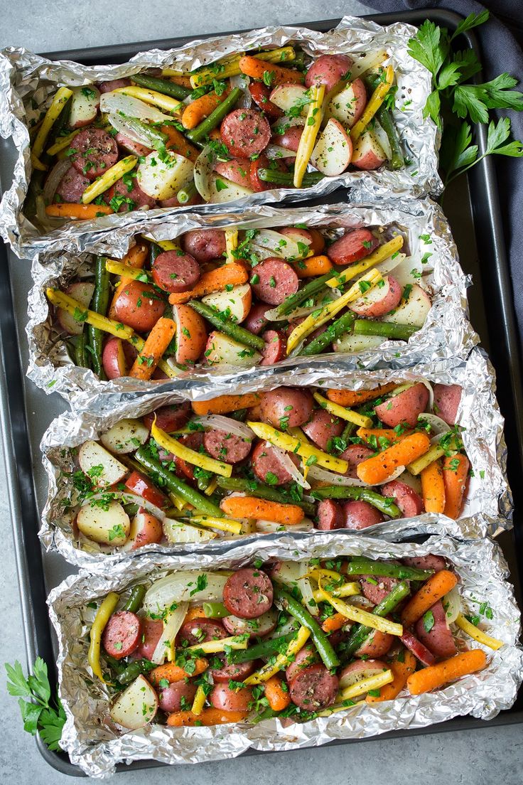 three trays filled with different types of food on top of each other and garnished with parsley