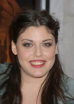 a woman with long dark hair smiling at the camera