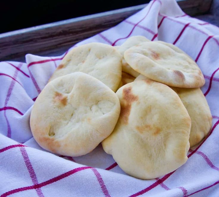 four pita breads sitting on top of a towel