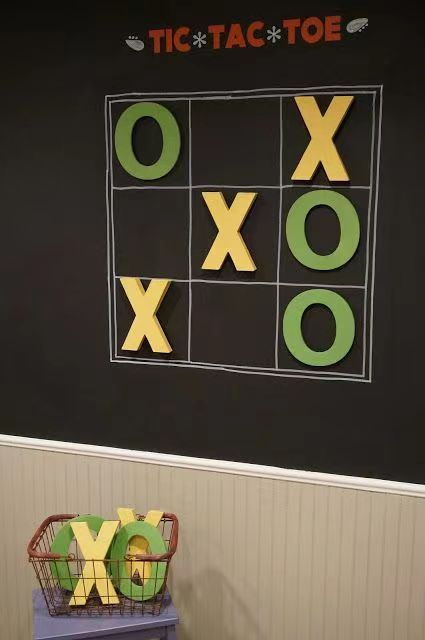 a tic tac toe board on the wall next to a basket with letters