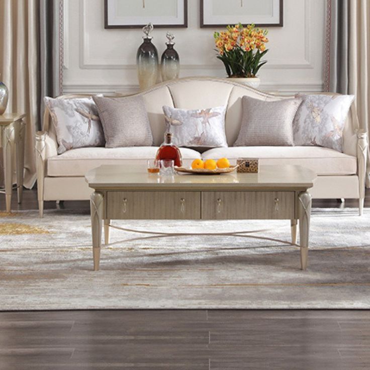 a living room with couches, tables and vases on top of the coffee table