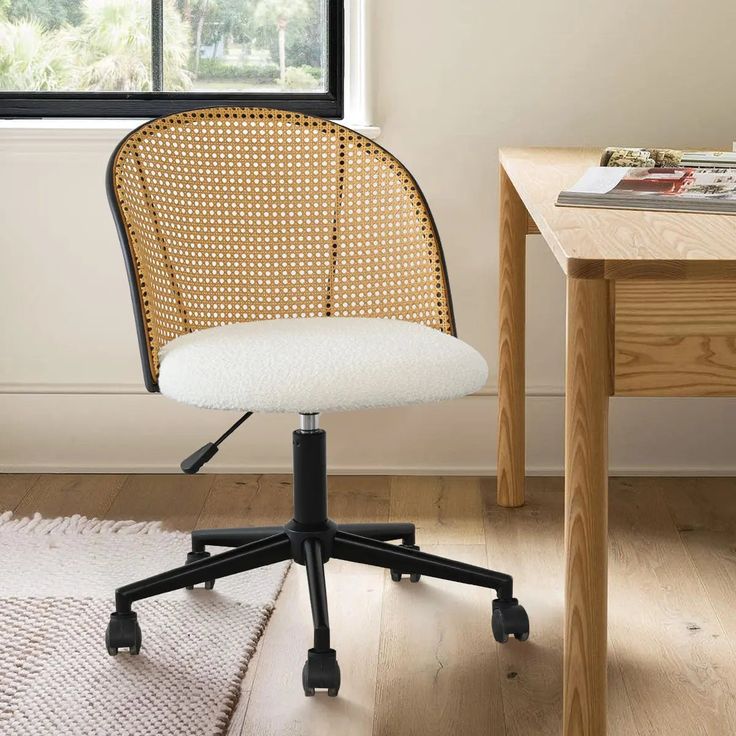 an office chair sitting on top of a wooden floor next to a window and rug