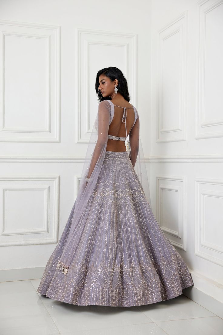 Lilac organza lehenga with glass beads, zardozi and pearl embellishments paired with raw silk embroidered blouse with long tulle cape sleeve.From Chamee and Palak's The Romantics collection.DELIVERY TIMEPlease allow 8-12 weeks for your outfit to arrive.FABRIC DETAILSOrganza, Silk, NetProfessional cleaning only. Elegant Anarkali Set With Cape Sleeves And Dupatta, Designer Anarkali Set With Sheer Dupatta And Cape Sleeves, Festive Gown With Zari Work And Cape Sleeves, Reception Sharara With Cape Sleeves And Dupatta, Anarkali Set With Sheer Dupatta And Cape Sleeves, Sharara With Cape Sleeves And Dupatta For Reception, Festive Gown With Sheer Dupatta And Cape Sleeves, Eid Georgette Lehenga With Cape Sleeves, Georgette Lehenga With Sheer Dupatta And Cape Sleeves