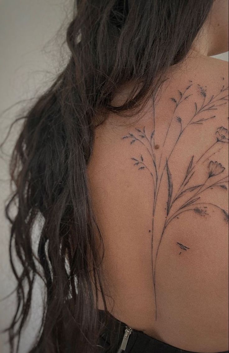 the back of a woman's shoulder with flowers on it