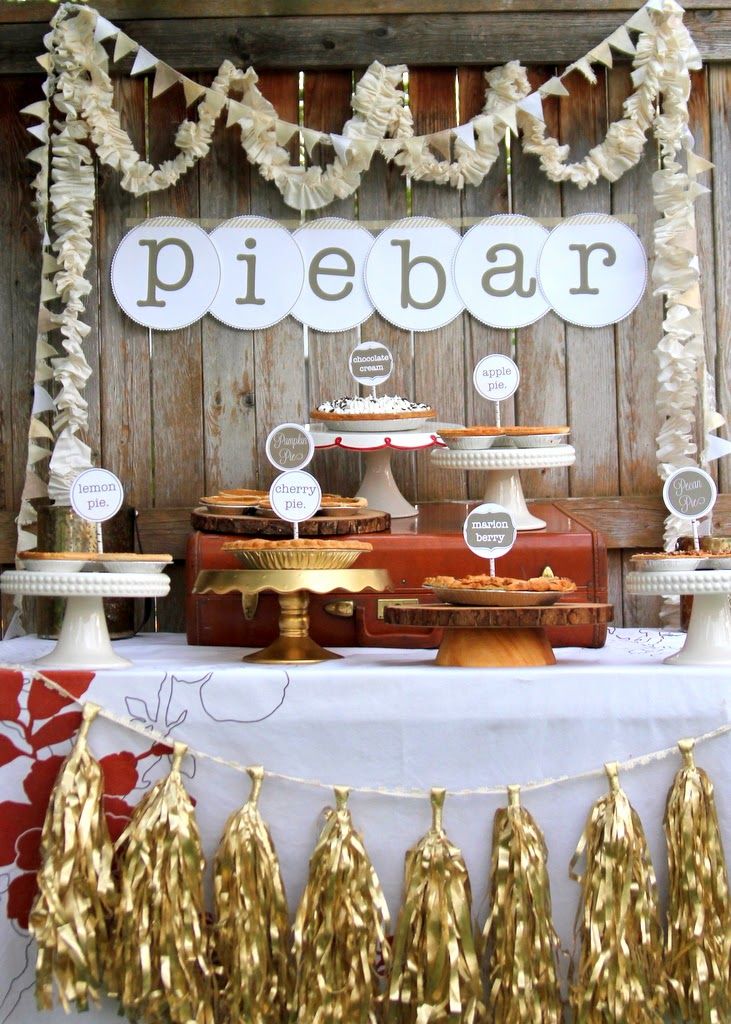 a table with cake and desserts on it in front of a wooden wall that says piebar