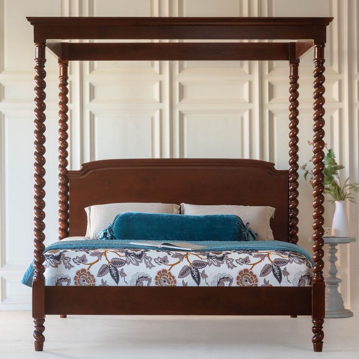 a four poster bed with blue and white pillows