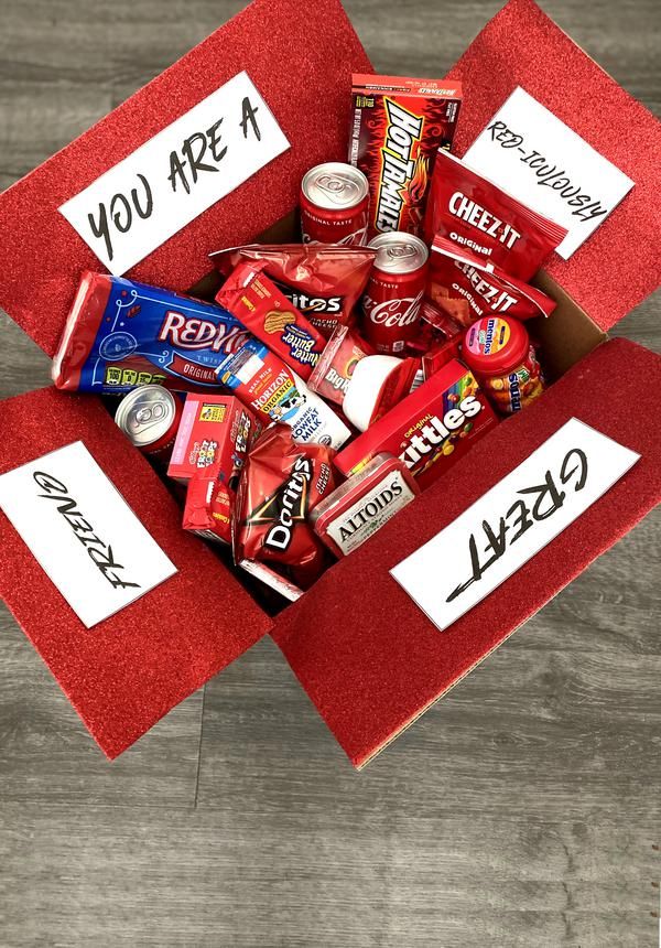 a red box filled with candy on top of a wooden floor