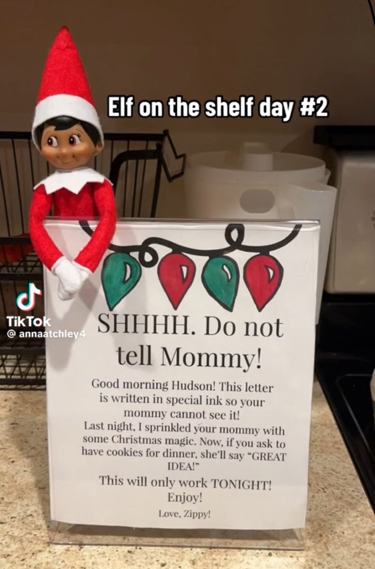 an elf is holding a sign that says, elf on the shelf day 2