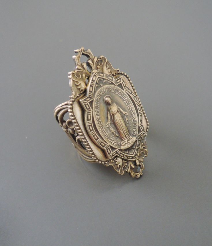 "Vintage Jewelry - Vintage Ring - Virgin Mary Ring - Brass Ring - Catholic Jewelry - Adjustable Ring - handmade jewelry This is such a beautiful vintage ring. A vintage medal of the Blessed Virgin Mary beautifully adorned on a vintage filigree adjustable ring. Can be adjusted to fit any finger. Wonderful warm patina and detail. Chloe says, \"Wear it and feel fabulous!\" This ring measures 1 3/4\" wide. The ring is set at size 6 and can be squeezed smaller or pulled apart easily to a size 11. Tha Spiritual Bronze Jewelry For Anniversary, Bronze Open Ring Jewelry For Anniversary, Collectible Spiritual Jewelry Ring, Unique Nickel-free Jewelry For Wedding, Spiritual Collectible Jewelry Rings, Unique Nickel-free Wedding Jewelry, Unique Wedding Jewelry In Lost Wax Casting, Unique Lost Wax Casting Jewelry For Wedding, Unique Wedding Jewelry With Lost Wax Casting