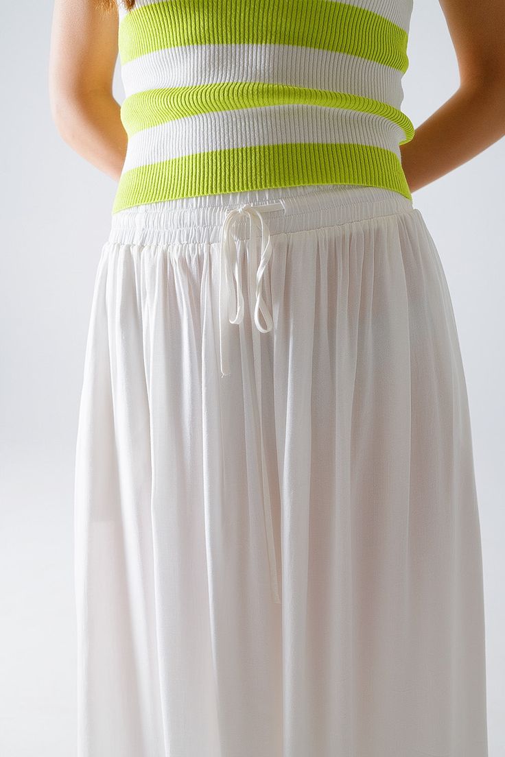 Introducing our stunning Maxi Skirt in White Fluid Fabric with Elastic Waist, a versatile and chic addition to your wardrobe that exudes effortless bohemian style. Crafted from lightweight woven fabric made of 100% viscose, this skirt offers both comfort and elegance.  The full-length design and relaxed fit create a flowing silhouette that's perfect for any occasion, whether you're strolling along the beach or attending a summer soirée. The elastic waistband ensures a comfortable and customizable fit, while side pockets add a practical touch.  Pair this skirt with a simple tank top for a casual daytime look, or dress it up with a blouse and statement jewelry for a more polished ensemble. However you style it, this maxi skirt is sure to make a statement wherever you go.  Please note that th Flowy Maxi Skirt, Simple Tank Tops, Flowy Maxi Skirts, Boho Fabric, Summer Soiree, Skirt Jumpsuit, Scarf Headband, Estilo Boho, Style Boho