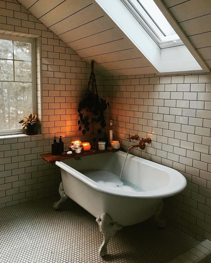 a bathroom with a claw foot tub in the corner and candles on the counter next to it