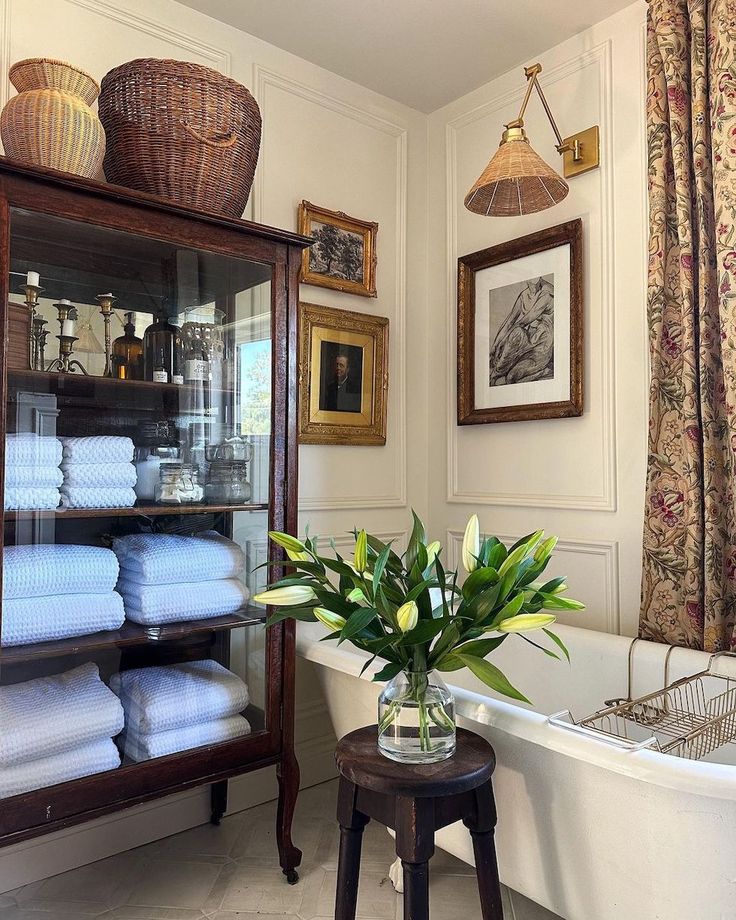 a white bath tub sitting next to a shelf filled with towels