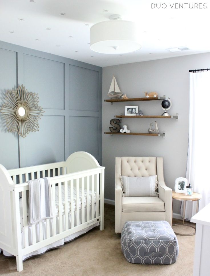 a baby's room with a white crib, chair and shelf on the wall