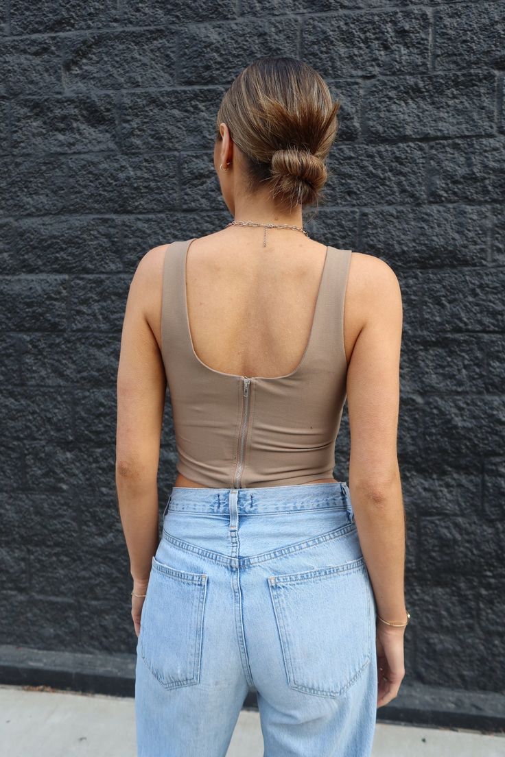 DETAILS: Our Haliee Mocha Tank is a fitted crop top that features two dart stitches in the side bust to give it a bustier look, thick shoulder straps (not adjustable), scoop neckline, and an striaght hemline. This item is lined. This is the perfect top to pair with a statement overpiece! CONTENT & CARE: SELF: 76% Nylon, 24% Spandex. LINING: 76% Nylon, 24% Spandex. SIZE & FIT: Model is 5'6" The model is wearing a size Small. Fits true to size The Fabric has stretch Stretch Crop Top With Built-in Bra And Wide Straps, Chic Scoop Neck Crop Top With Built-in Bra, Casual Crop Top With Medium Bust Support, Seamless Scoop Neck Crop Top For Night Out, Cropped Tank Top With Medium Bust Support, Scoop Neck Crop Top For Night Out, Chic Crop Top With Built-in Bra And Wide Straps, Fitted Tank Crop Top With Built-in Bra, Chic Tank Crop Top, Bra-friendly