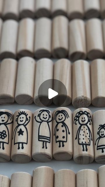 several wooden pegs with drawings of people on them