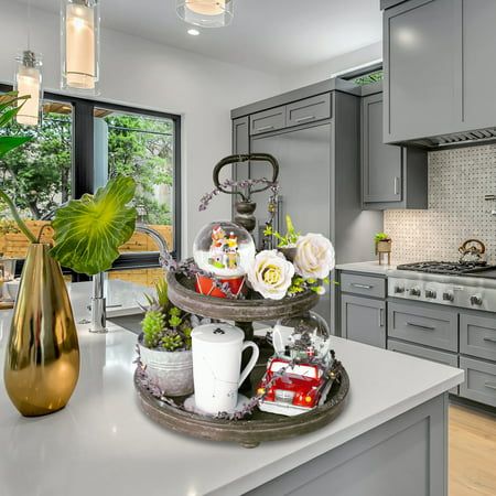 a kitchen with grey cabinets and white counter tops, an island in the middle has flowers on it