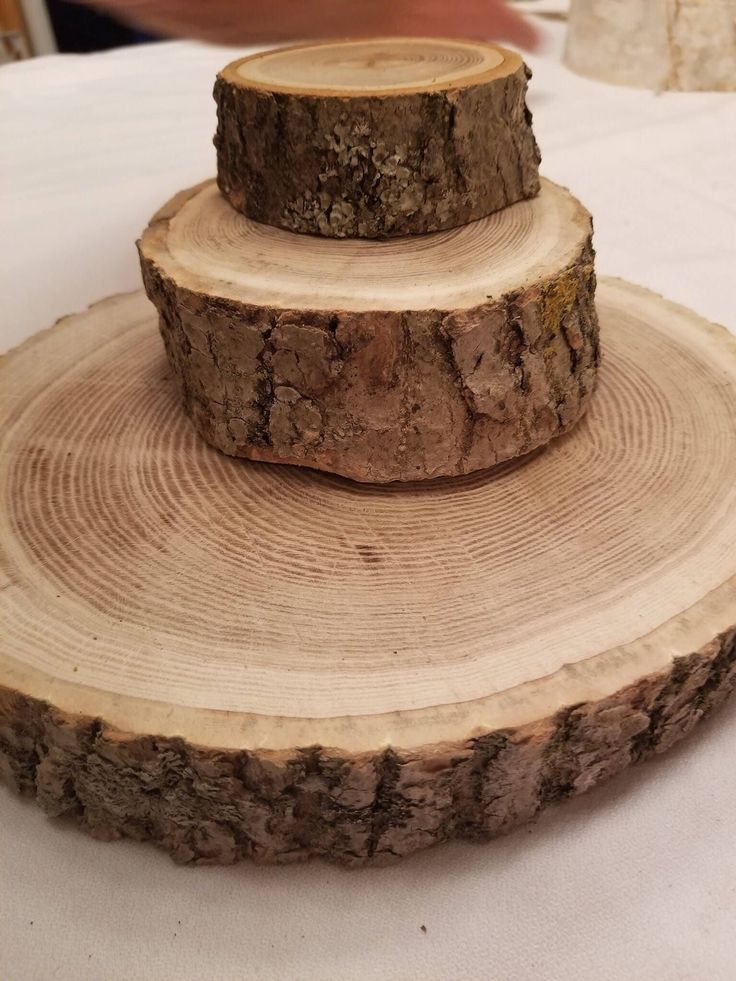 a stack of logs sitting on top of a table next to a white table cloth