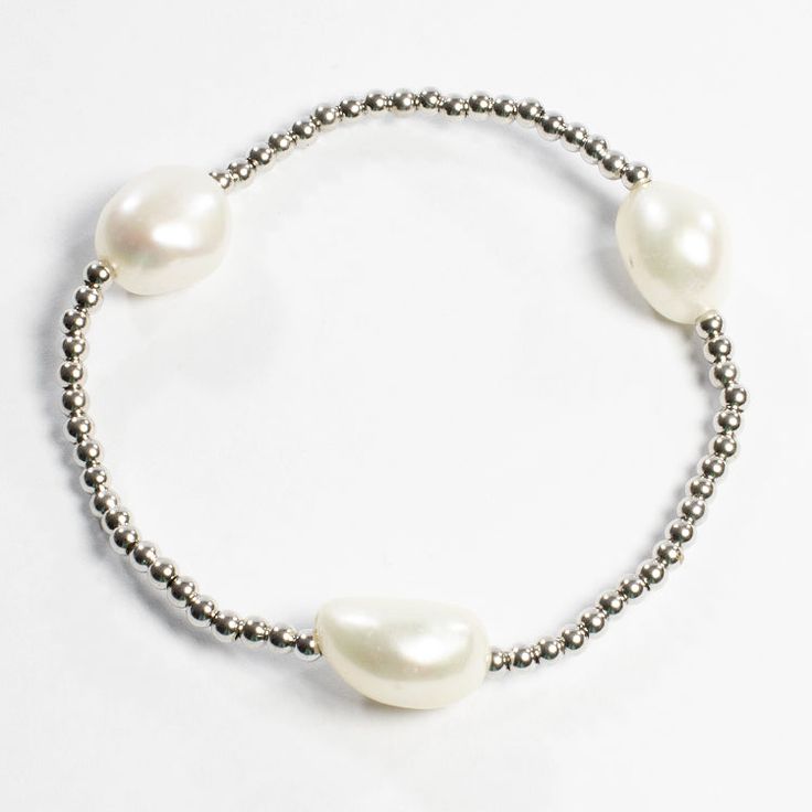 This contemporary sterling silver bracelet adorned with three freshwater pearls is the perfect addition to any wardrobe. This stretch bracelet is easy to wear and can be worn by itself or added to a stacking bracelet collection. We suggest to wear more than one for a spectacular look. They are a perfect gift for any woman. - Stones Material: Freshwater Pearl. - Stones Shape: Natural Shape of Freshwater Pearl. - Metal: 925 Sterling Silver. - Plating: Gold and Rhodium plated. - Length: Aprox. 7" a Silver Pearl Stretch Bracelet, Pearl Bracelet Gold, Bracelet Collection, Natural Shapes, Sterling Silver Bracelet, Bracelet Stack, Stretch Bracelet, Pearl Bracelet, Stretch Bracelets