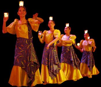 a group of women standing on top of a stage holding candles in their hands and wearing dresses