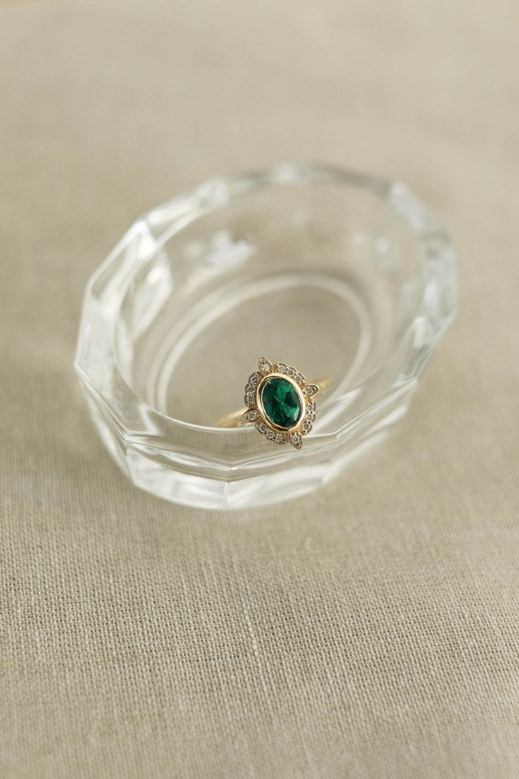 Elegant Emerald Ring With Oval Cabochon, Heirloom Style Emerald Ring With Halo For Formal Occasions, Oval Emerald Ring With Halo Setting For Formal Occasions, Elegant Oval Emerald Ring With Halo Setting, Oval Emerald Ring With Halo Design, Vintage Oval Jewelry With Halo, Vintage Oval Halo Jewelry, Classic Oval Emerald Ring With Bezel Setting, Elegant Oval Emerald Ring For May Birthstone