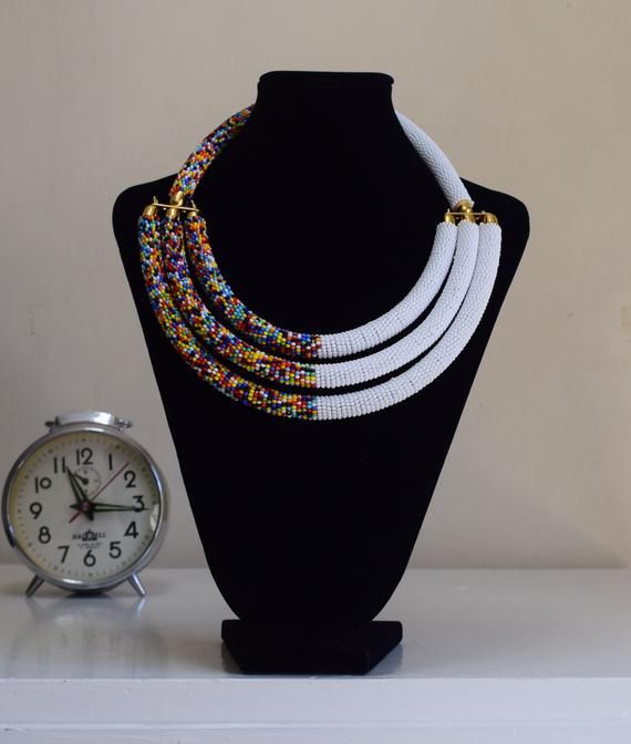 Unique African Maasai Handcrafted Beaded Necklace with an Elegant Look and Brilliant Finish.**GET FREE SHIPPING FOR ADDITIONAL ITEMS PURCHASED.Yes, Buy Multiple Items and pay shipping for 1 item only- The rest ships Free. (No Limits on the number of Multiple items). With a faster delivery time of 3 days via DHLExpress, Worldwide. Ordinary/Standard Shipping also available upon request. We Custom Make to Suit Your Taste.Available In All Colors and Sizes.For wholesale please chat me up for discount Bohemian White Jewelry With Black Beads, White Bohemian Necklace With Black Beads, Traditional White Choker With Round Beads, Traditional White Necklace With Colorful Beads, Bohemian White Beaded Chain Choker, Traditional White Handmade Necklace, Traditional Handmade White Necklace, White Bohemian Beaded Chain Choker, White Bohemian Choker With Beaded Chain