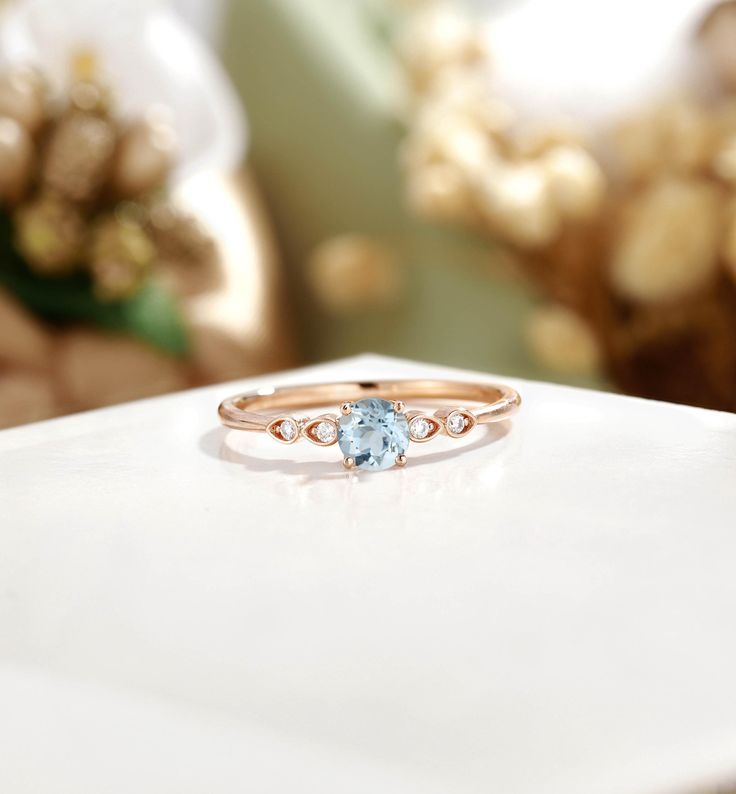 a close up of a ring with a blue stone in it on a white surface