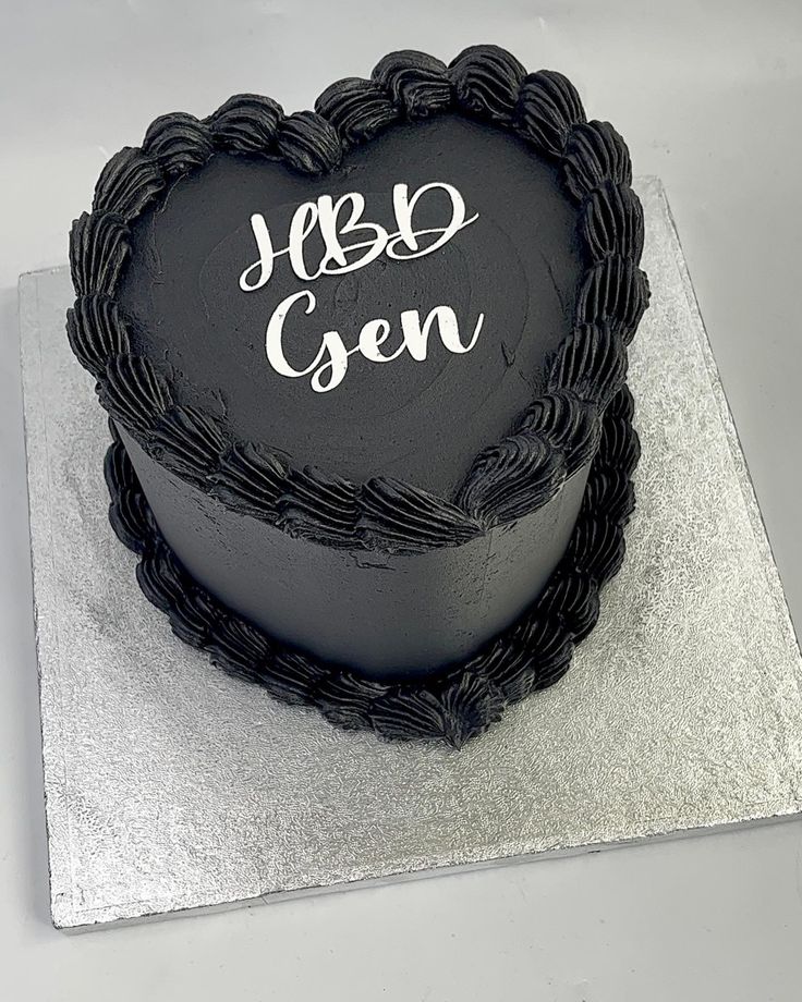 a heart - shaped cake with the words yes gen on it is sitting on a silver platter