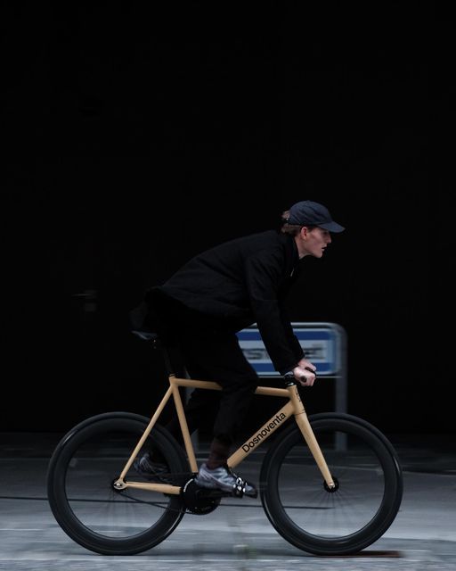 a man riding on the back of a wooden bike in front of a black background