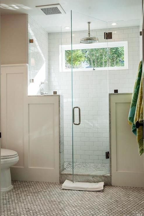 a bathroom with a walk in shower next to a white toilet and tiled flooring