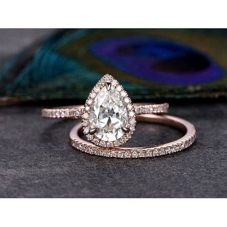 a close up of a ring on a table with a peacock feather in the background