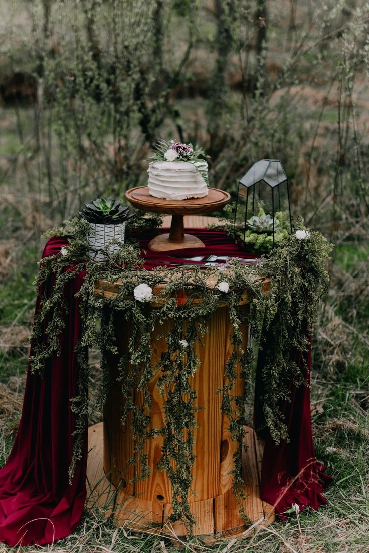 a cake on top of a wooden table in the grass