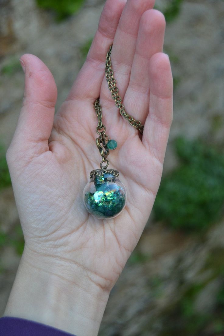 PLEASE read my shop announcement before placing an order so you know what to expect right now. Plus, when ordering from outside Europe, don't forget to provide a phone number for the courier to ensure the fastest and smoothest delivery. Wizard of Oz inspired necklace featuring a magical glass orb enclosing some emerald green iridescent glitter in various sizes and a few amazing emerald faceted crystals. The glass ball, in a charming Vintage style, dangles from a quatrefoil shape adorned with a g Whimsical Green Pendant Jewelry, Spiritual Green Round Pendant Crystal Necklace, Spiritual Green Crystal Round Pendant Necklace, Green Round Pendant Crystal Necklace For Spiritual Purposes, Green Round Pendant Crystal Necklace For Spiritual Use, Green Glass Necklace For Party, Whimsical Green Nickel-free Jewelry, Green Charm Necklace For May Birthstone Gift, Green Round Pendant Jewelry Keepsake