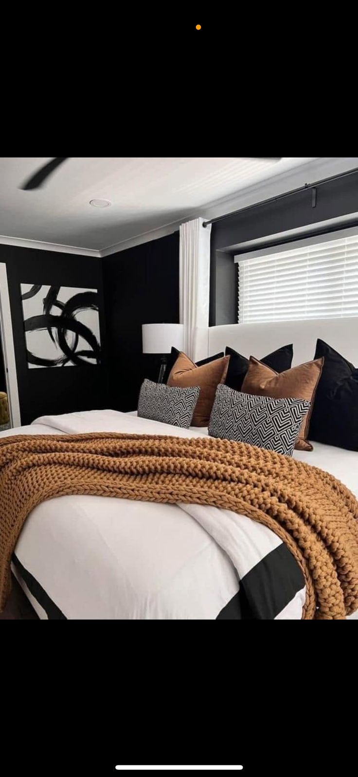 a bed with rope on the headboard and pillows in black and white color scheme