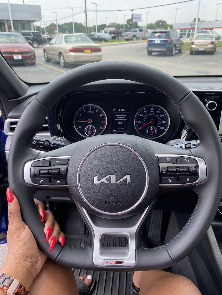 a woman holding the steering wheel of a car