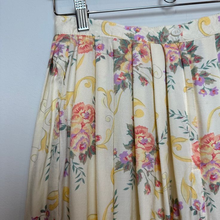 This pleated midi skirt by Susan Bristol is a vintage 80s floral pattern midi skirt and is made in the USA. 100% rayon. Cream/yellow color with pink and purple floral design. Item does have several spots throughout, as shown in photos. Women's size 8. Measurements with the garment laying flat: Waist: about 13.5 inches Length: about 34 inches Vintage Lined Pleated Skirt For Summer, Vintage Pleated Lined Skirt For Spring, Spring Vintage Skirted Bottoms, Vintage Flowy Pleated Skirt For Spring, Vintage Spring Midi Pleated Skirt, Vintage Spring Pleated Midi Skirt, Spring Vintage Pleated Skirt, Vintage Pleated Midi Skirt For Spring, Vintage Pleated Skirt For Spring