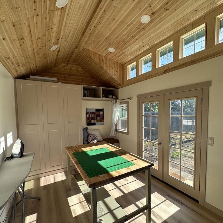 a room with a table and some doors in it's center area, next to a sliding glass door that leads out onto the yard