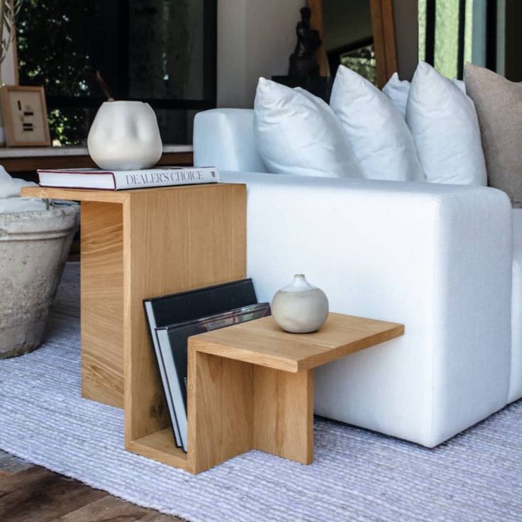 a white couch sitting on top of a wooden table next to a potted plant