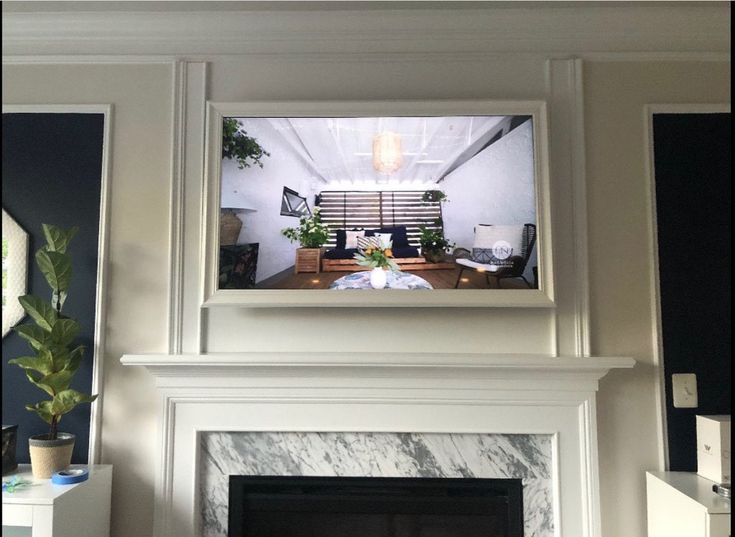 a living room with a fireplace and tv mounted above the mantel in front of it