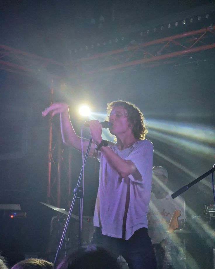 a man standing in front of a microphone on top of a stage