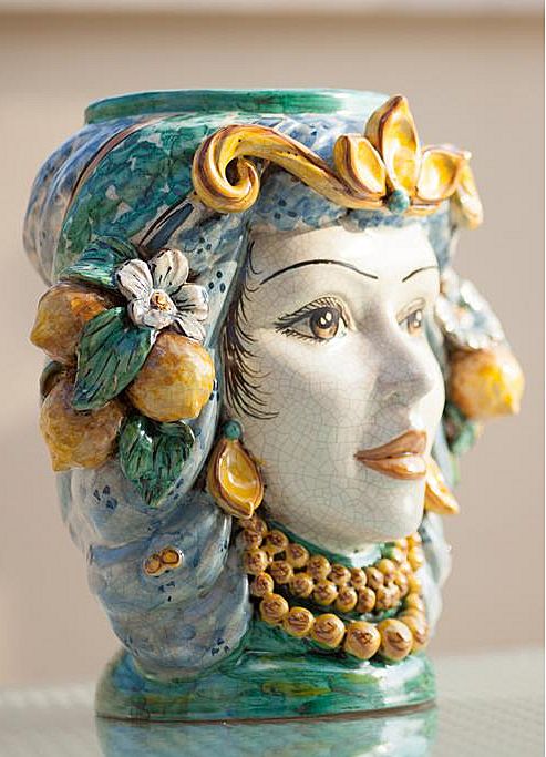 a ceramic vase with a woman's face painted on it