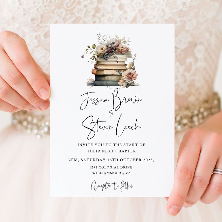 a person holding up a card with a book and flowers on it in front of their wedding dress