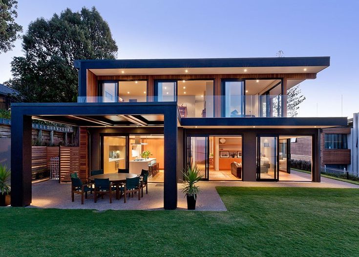 an image of a modern house in the evening time with grass and trees around it